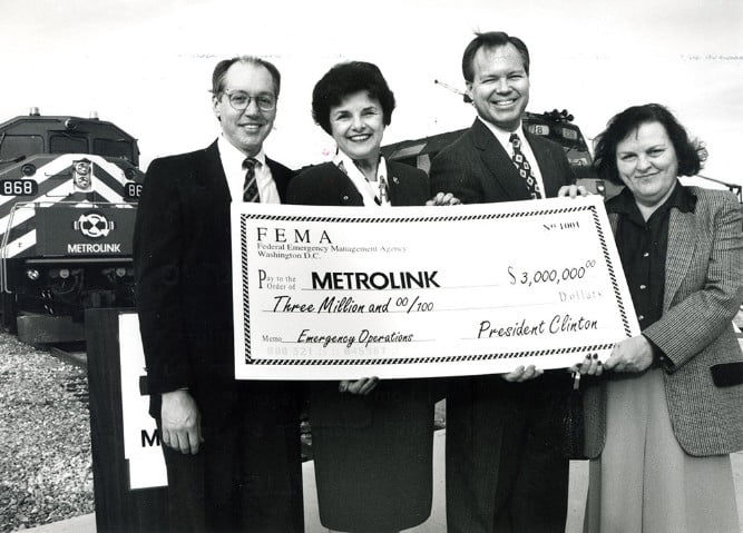 4 people happy about an oversized 3 million dollar check for Metrolink from President Clinton