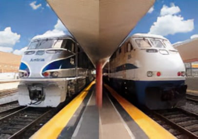 Symmetrical shot of two trains at a station on parallel tracks